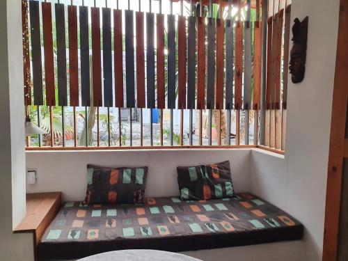 - un petit banc dans une chambre avec fenêtre dans l'établissement Casa Norte, à Baia das Gatas