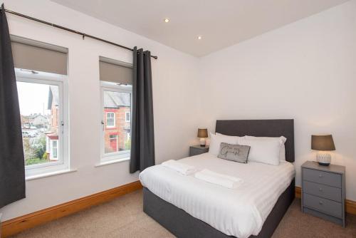 a bedroom with a bed and two windows at Trafalgar Terrace in Darlington