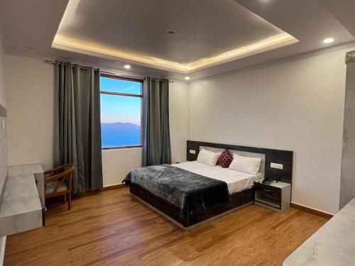 a bedroom with a bed and a large window at Fantastic Three Bedroom Apartment in Shimla