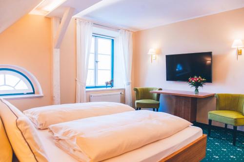 a hotel room with two beds and a desk at Gutshaus Neu Farpen in Neuburg