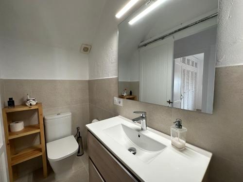 bagno con lavandino, servizi igienici e specchio di ALDEAMAR F1 by SOM Menorca a Son Parc
