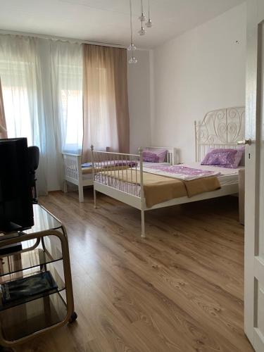 a bedroom with a bed and a wooden floor at City Apartment in Schweinfurt