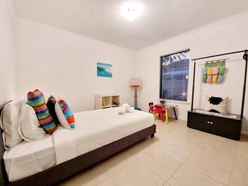 a bedroom with a bed and a table and a window at Modern Family Escapes Shopping at your doorstep in Perth