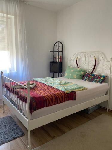 a bedroom with a white bed with a red blanket at City Apartment in Schweinfurt