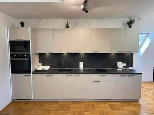 a kitchen with white cabinets and a black counter top at SOBEL II in Tylmanowa