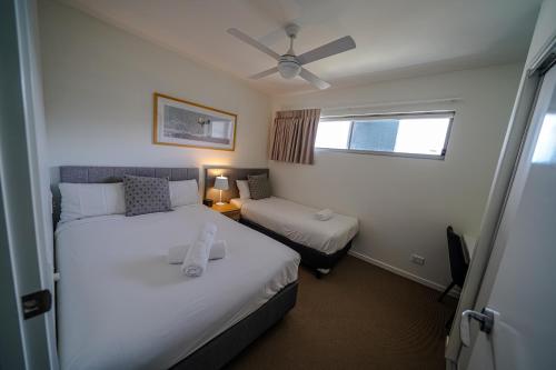 a hotel room with two beds and a window at Aquarius Kawana in Kawana Waters