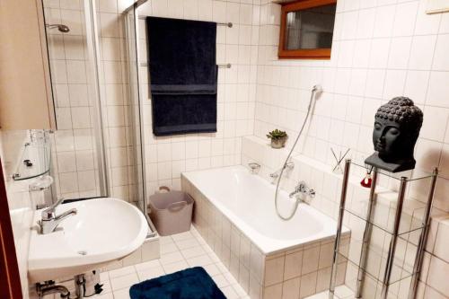 a bathroom with a sink and a bath tub and a mask at City-close oasis in the green in Deggendorf