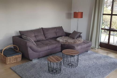 a living room with a purple couch and two tables at City-close oasis in the green in Deggendorf