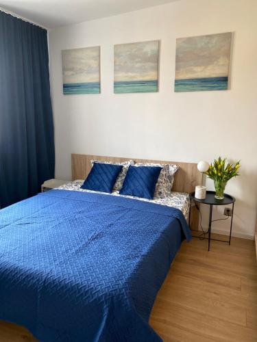 a bedroom with a blue comforter on a bed at Bresno8 in Gdańsk