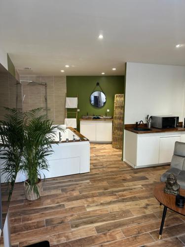 a room with a kitchen and a living room with wooden floors at Jungle room in Sotteville-lès-Rouen