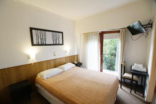 Habitación de hotel con cama y ventana en Alsina Suites en Mar del Plata