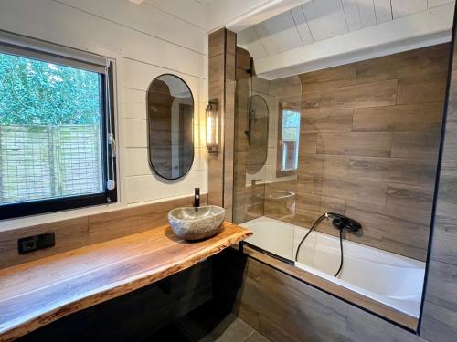 La salle de bains est pourvue d'un lavabo et d'une baignoire. dans l'établissement KempenLodge, luxe boshuis voor 8 pers, in Brabantse natuur, à Diessen