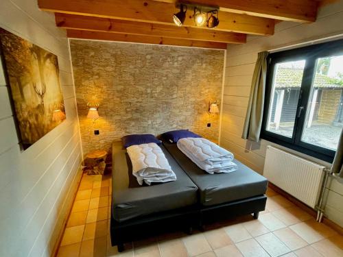 Ένα ή περισσότερα κρεβάτια σε δωμάτιο στο KempenLodge, luxe boshuis voor 8 pers, in Brabantse natuur