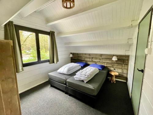 a small bedroom with a bed in a tiny house at KempenLodge, luxe boshuis voor 8 pers, in Brabantse natuur in Diessen