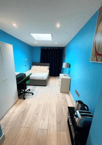 a bedroom with a bed and a desk in a room at Letzi Ensuite, 15 Min to Heathrow, Fast WiFi in Hayes