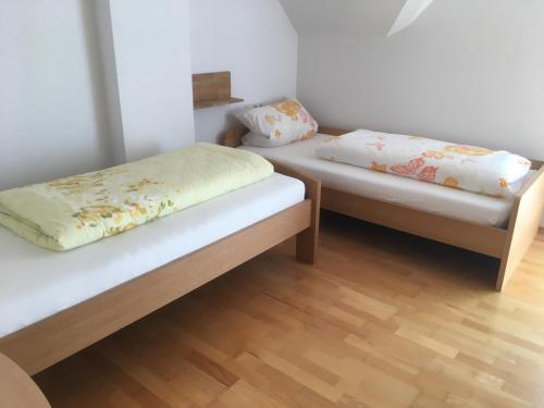 two twin beds in a room with wooden floors at Ferienwohnung Arnika 