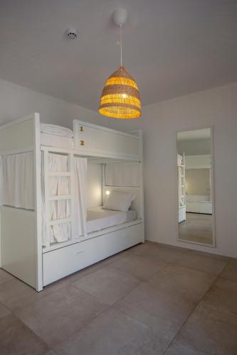 a bedroom with a white bunk bed and a light fixture at Sun Lovers Hostel in Albufeira