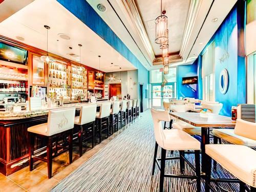 a restaurant with a bar with white chairs at Amalz 1 Bedroom 2 Bathroom Balcony Suites at Mgm Signature ! in Las Vegas