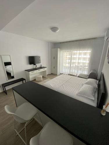 a bedroom with a large bed with a desk and chairs at Casa del Mar in Mamaia