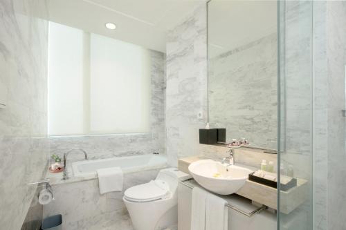 ジャカルタにあるフレイゾーズ レジデンス スディルマン ジャカルタのバスルーム(トイレ、洗面台、バスタブ付)
