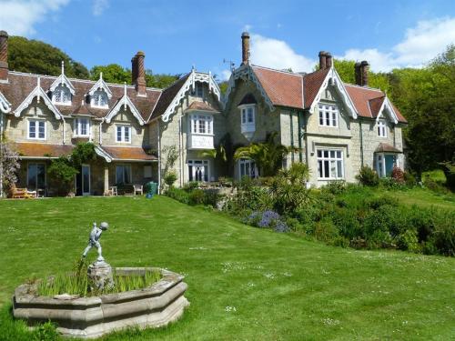 una casa grande con una estatua delante de ella en Lisle Combe, en Ventnor