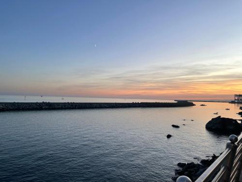 un tramonto su un corpo d'acqua con rocce di La Casa di Pegli 21r a Genova