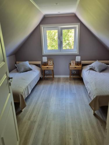 ミエンジズドロイェにあるDomki letniskowe bez zwierzątの屋根裏のベッドルーム(ベッド2台、窓2つ付)
