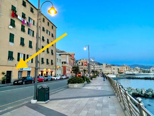 a yellow arrow on a street light next to a road at La Casa di Pegli 21r in Genoa