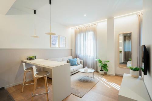 a kitchen and living room with a table and a couch at Fisa Rentals Ramblas Apartments in Barcelona