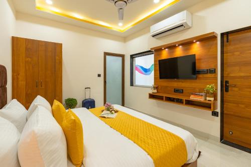a bedroom with a large bed with a tv on the wall at The Social Stays Jaipur formerly ArtBuzz in Jaipur