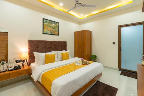 a bedroom with a large bed with yellow pillows at The Social Stays Jaipur formerly ArtBuzz in Jaipur