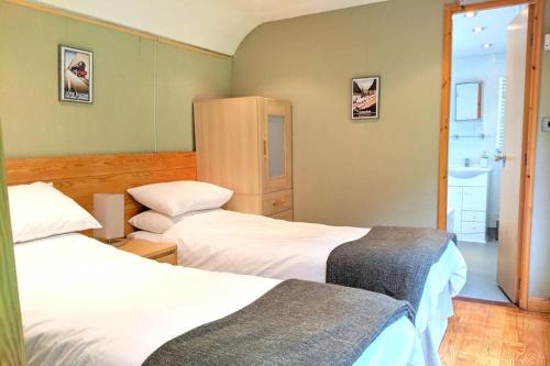 a hotel room with two beds and a window at Carriage 2 - Coalport Station Holidays in Telford