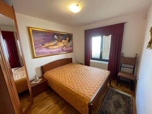 a bedroom with a bed and a painting on the wall at Apartma pri Gradu in Brežice