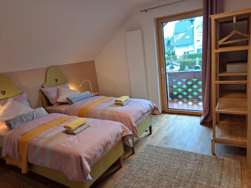 a bedroom with two beds and a large window at Room Art&deco in Bled