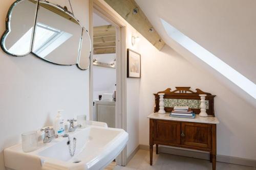 a bathroom with a sink and a mirror at Stylish Cottage in the Pewsey Vale in Marlborough