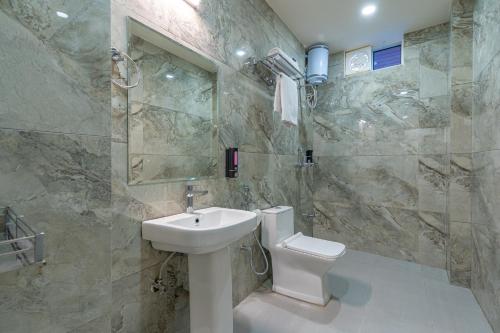 a bathroom with a white sink and a toilet at The Social Stays Jaipur formerly ArtBuzz in Jaipur