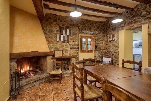 サン・ジョアン・レス・フォンツにあるMas Molera Turisme Ruralの暖炉と木製テーブル付きのダイニングルーム
