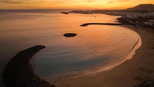 an aerial view of a beach at sunset at Dreams Lanzarote Playa Dorada Resort & Spa in Playa Blanca