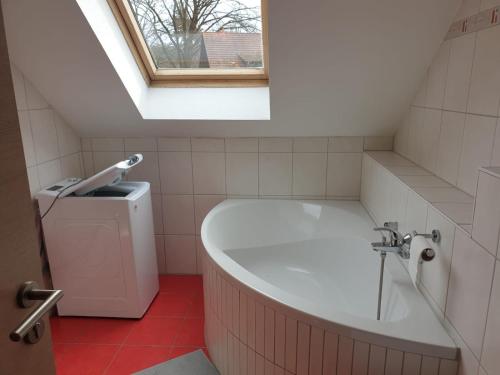 ein Bad mit einer Badewanne und einem Fenster in der Unterkunft Ferienwohnung 6 - Gourmetzimmer in Bestensee