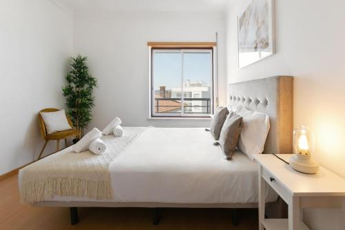 a bedroom with a bed with a desk and a window at Green Hill in Nazaré