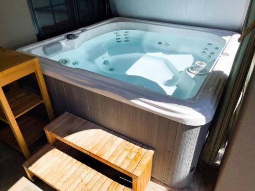 uma banheira de hidromassagem com um degrau de madeira num quarto em Modern Castle with Kitchen Hot Tub, Cafe, Office em San José