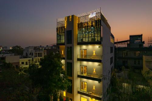 a tall building with lights on it at dusk at The Social Stays Jaipur formerly ArtBuzz in Jaipur