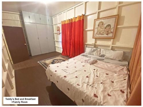 um pequeno quarto com uma cama e uma cortina vermelha em Teddys Bed & Breakfast lodge 