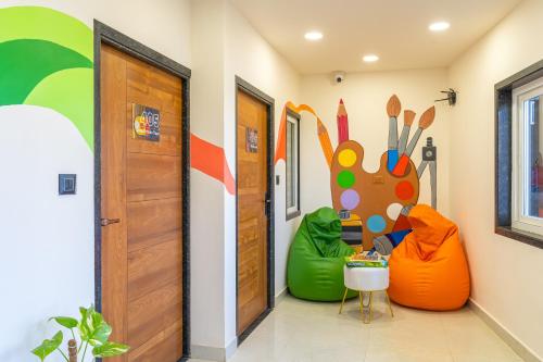 a hallway with a room with an orange door and green and orange balls at The Social Stays Jaipur formerly ArtBuzz in Jaipur