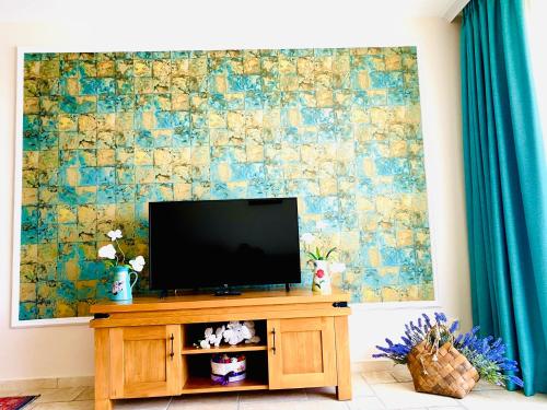 a television on a wooden entertainment center in a living room at Royal Apartment Sea view by Kaliakria in Topola