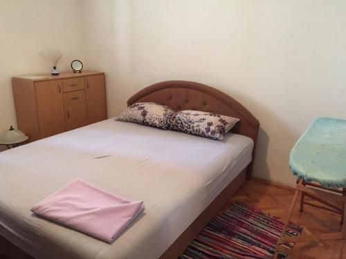 a bedroom with a bed with a pillow and a chair at Rakite Apartment in Kotor