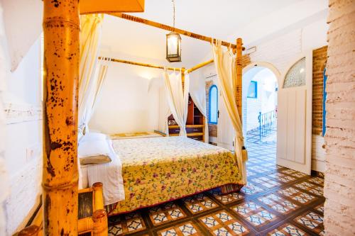 a bedroom with a bed with a canopy at Casa Rural La Pontezuela in El Puente del Arzobispo