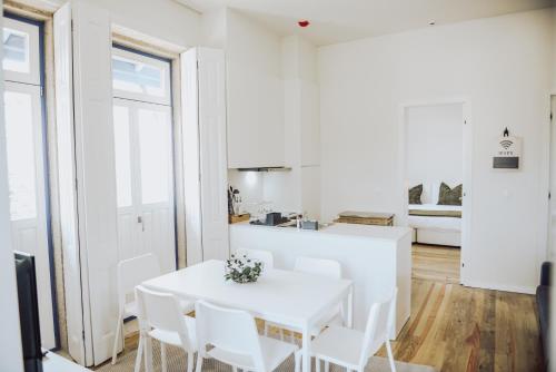 - une salle à manger blanche avec une table et des chaises blanches dans l'établissement Estação Ferroviária de Mondim de Basto, à Castelbuono