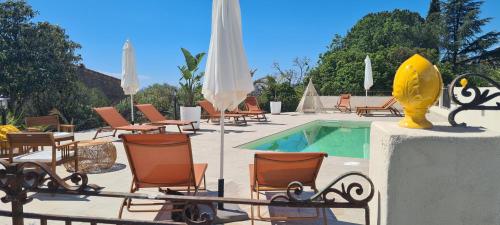 einen Pool mit Stühlen und Sonnenschirmen neben einem Pool in der Unterkunft Peiranze144 b&b in Sanremo