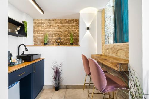 a kitchen with two purple chairs and a sink at מלון הליוס בוטיק מרשת מלונות לה פינקה in Beer Sheva